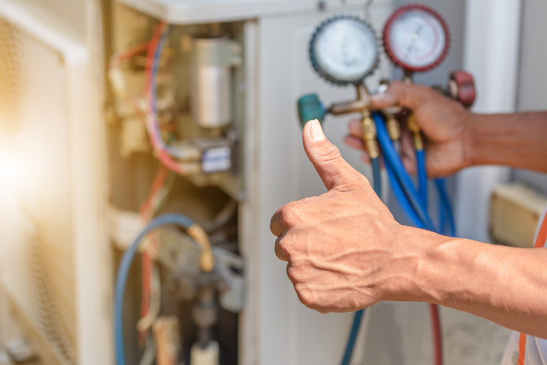 a person giving the thumbs up to an air conditioner