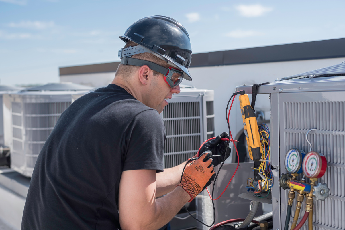 a person working on an air conditioning unit